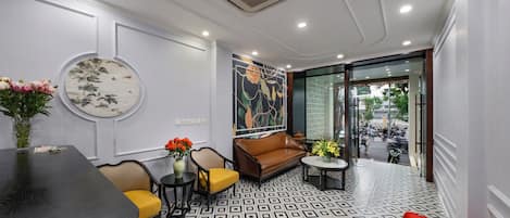 Un interior moderno con una mesa de comedor redonda, un sofá marrón y un suelo estampado.
