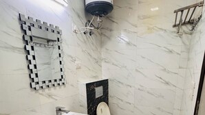 A bathroom with a white sink, a toilet, and a mirror. - Ambient Express Cr Park (New Delhi)