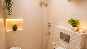 A modern bathroom with a toilet, shower, and sink.
