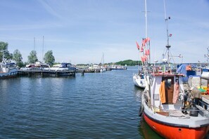 Eine Marina mit verschiedenen vertäuten Booten, ruhigem Wasser und wolkenlosem Himmel.