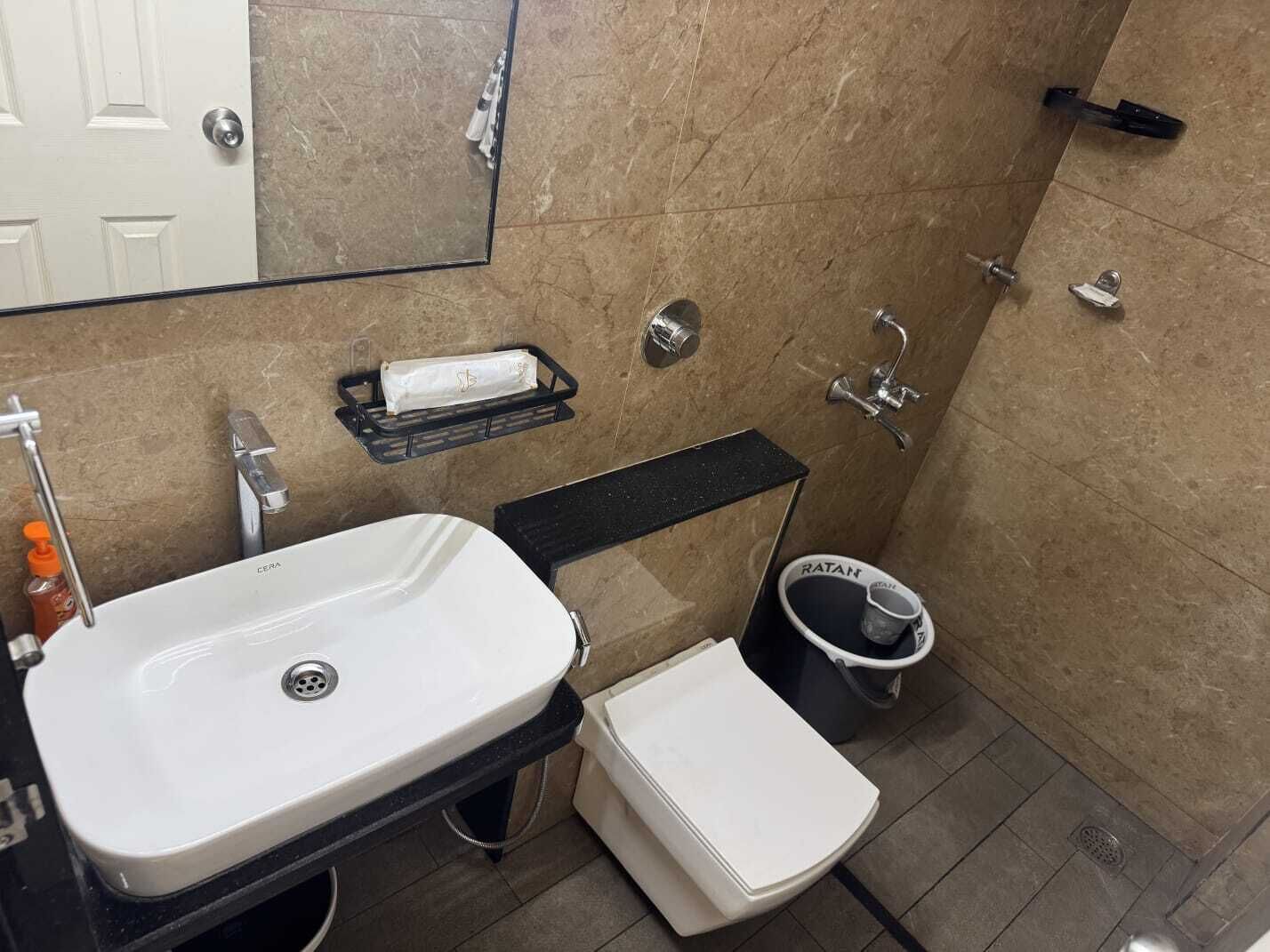 Un baño pequeño con lavamanos blanco, inodoro y zona de ducha.