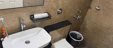 Un baño pequeño con lavamanos blanco, inodoro y zona de ducha.