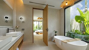 Un baño moderno con una bañera independiente, dos espejos redondos y un amplio ventanal con vistas a zonas verdes.