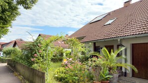 A residential street with houses, a wooden fence, and potted plants. - Apartment 'Birkach 35' with Balcony and Wi-Fi (Lindau am Bodensee)