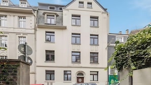 Un edificio de varios pisos con fachada simétrica, múltiples ventanas y una entrada central.