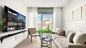 A modern living room with a flat-screen TV, a sofa, a chair, and a small table. - Red Canyon Peaceful Stay by Sea N' Rent (Eilat)