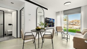 A modern living room with a dining area, a sofa, and a TV displaying 'TED LASSO'. - Red Canyon Peaceful Stay by Sea N' Rent (Eilat)