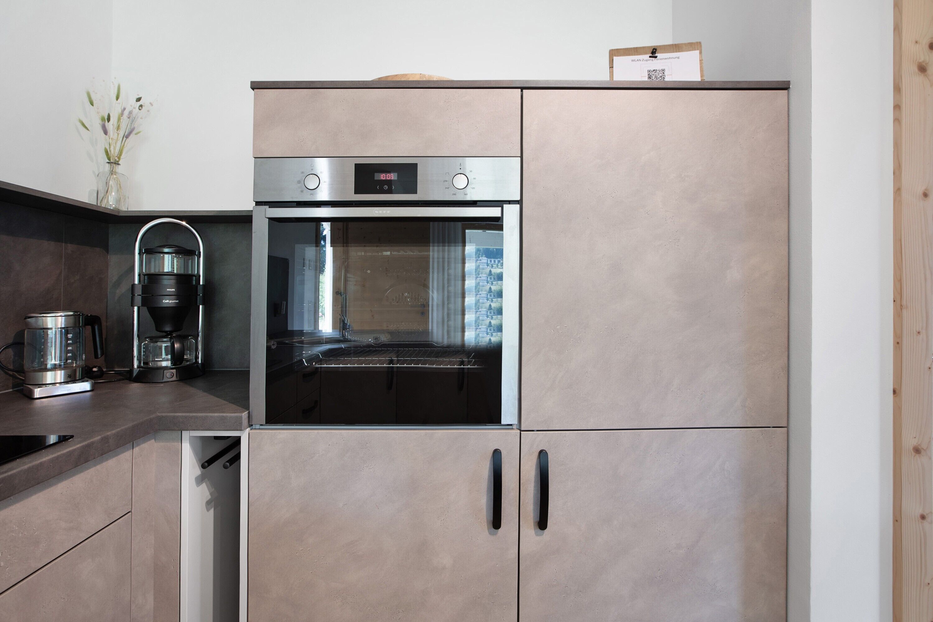A modern kitchen with a built-in oven, a coffee maker, and a dishwasher.