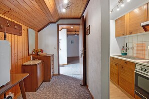 Una cocina con armarios de madera, una encimera y una estufa.
