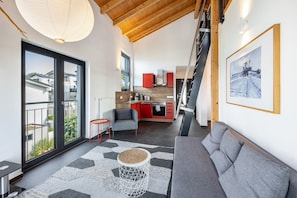Un salon moderne avec un canapé, une table basse et une cuisine en arrière-plan.