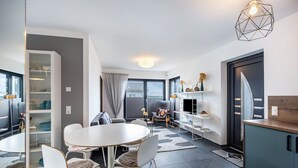 Een moderne keuken met een eethoek, een inbouwboekenplank en uitzicht door het raam.
