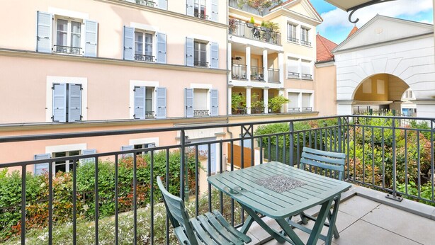 A balcony with a table and chairs, surrounded by a metal railing. - Puteaux - La défense - 2 chambres (Puteaux)