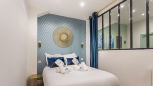 A bedroom with a bed, a round mirror, and a window with curtains. - 3. cosy 1BR - Père Lachaise - Nation (Paris)