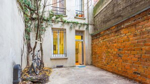 A narrow alleyway with a brick wall on one side and a building with a window on the other. - 3. cosy 1BR - Père Lachaise - Nation (Paris)