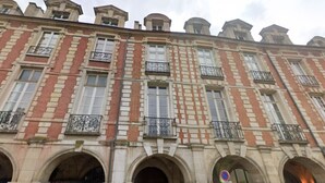 A historic building with a symmetrical facade, arched windows, and decorative iron railings.