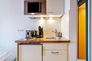 A compact kitchenette with a microwave, kettle, coffee maker, and a sink. - Apartment 'Halden' with Wi-Fi (Heiligenberg)