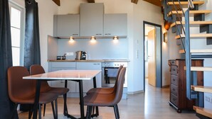 Una cocina moderna con comedor, escalera de madera y vistas al comedor.