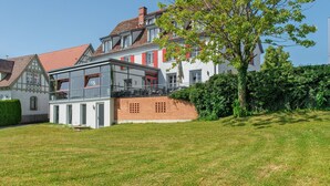 Un edificio de estilo europeo tradicional con fachada de ladrillo, múltiples ventanas y un balcón.