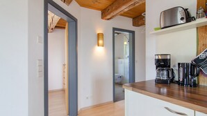 A kitchen with wooden beams, a toaster, a coffee maker, and a shelf with a mug. - Apartment 'Steigen' with Wi-Fi (Heiligenberg)
