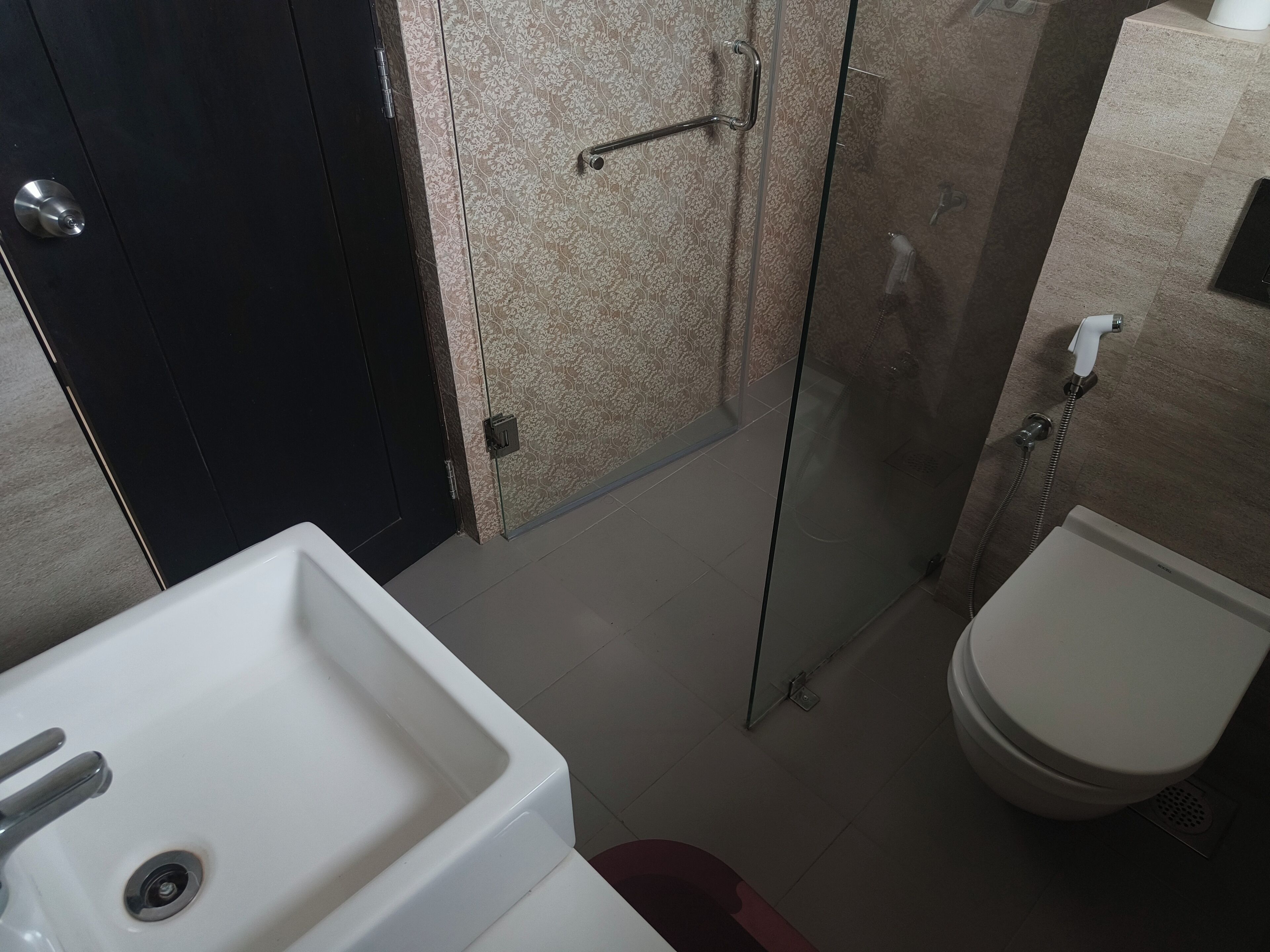 Un baño con un lavabo blanco, un inodoro y una cabina de ducha de cristal.
