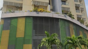 Een meerlaags woongebouw met balkons, een centrale verticale structuur en een kleurrijke gevel met geometrische patronen.
