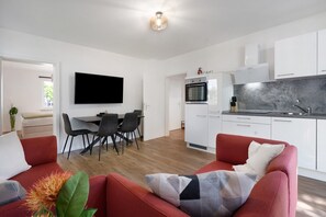 A modern kitchen with white cabinets, a built-in oven, and a grey backsplash. - Apartment 'In München Eg' with Shared Garden and Wi-Fi (München)