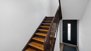 Una escalera con escalones de madera y barandilla de madera oscura.