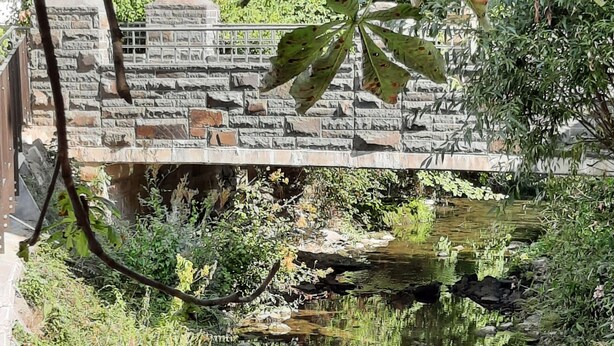 A stone bridge over a calm water body, surrounded by greenery and a stone wall. - Apartment 'Ferienwohnung' with Private Terrace, Private Garden and Wi-Fi (Eslohe)
