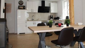 A modern kitchen with white cabinets, a black microwave, a coffee maker, and a wooden beam. - Apartment 'Ferienwohnung' with Private Terrace, Private Garden and Wi-Fi (Eslohe)