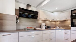 A modern kitchen with built-in appliances, a microwave, and a coffee maker.