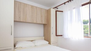 A bedroom with a bed, wooden wardrobe, and a window with curtains. - House B - 45m From the Sea (Vela Luka)