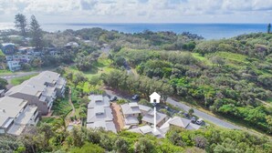 A residential area with multiple houses, a road, and a view of the ocean.