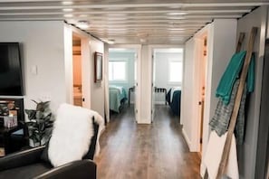 Enter a serene bedroom area through this inviting hallway, featuring a comfortable sofa and a stylish door leading to a cozy retreat.