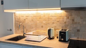 Une cuisine équipée d’un évier, d’un grille-pain et d’une bouilloire.