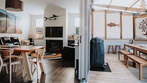 Un salon moderne avec une cheminée, des meubles en bois et des œuvres d’art accrochées aux murs.