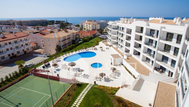 Un hôtel doté d’une piscine, d’un court de tennis et offrant une vue sur la mer.