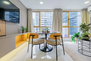 Una cocina moderna con comedor, ventanas amplias y un televisor de pantalla plana.