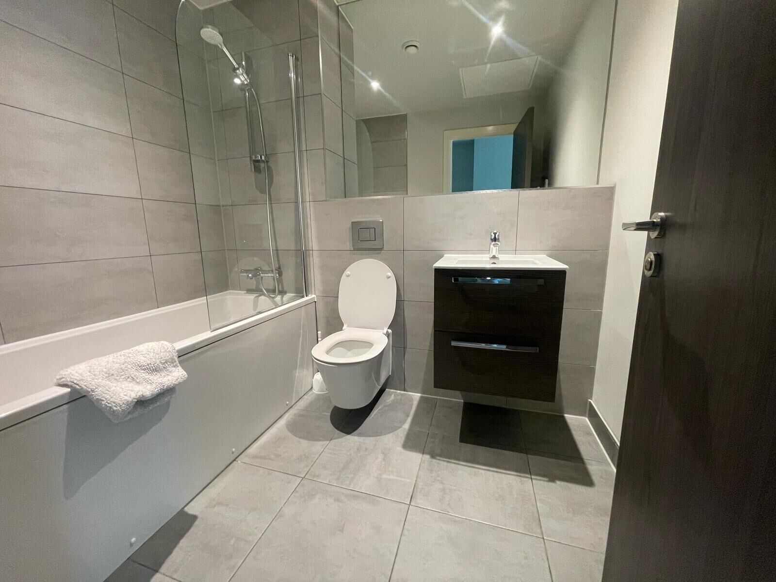 A modern bathroom with a bathtub, toilet, and sink.