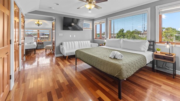 Una habitación de hotel con cama, sofá, escritorio y televisión.
