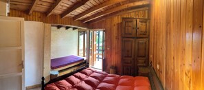 Cozy retreat with a single bed, wooden door, and natural light pouring in through the window.