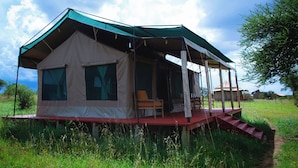 A tent with a covered porch and a staircase leading up to it. - Mlimwa Camp (Arusha)