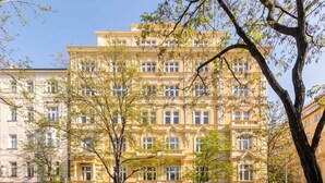 Un immeuble à plusieurs étages de style architectural classique, caractérisé par des fenêtres disposées de manière symétrique et des détails décoratifs élaborés.