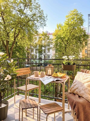 Ein Außenbereich mit Tisch, Stühlen und einer Bank.