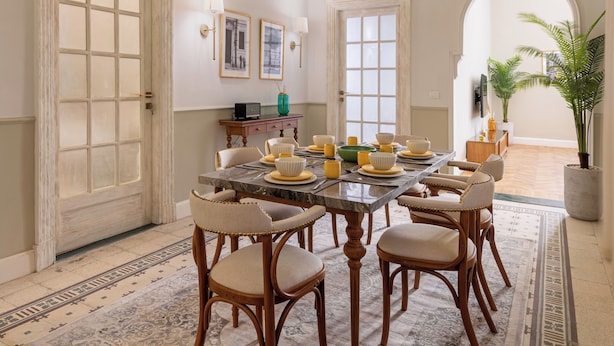 A dining room with a marble table, wooden chairs, and a chandelier. - Boutique Residence Layal-Lemon Spaces (Cairo)