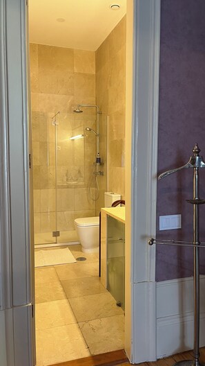 A modern bathroom with a glass-enclosed shower, a toilet, and a vanity with a mirror. - Vila Camélia - Suite Namorados (Porto)