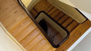 A staircase with a wooden floor and a white wall. - Vila Camélia - Suite Namorados (Porto)