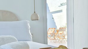 Een hotelkamer met een bed, een schaal met fruit en uitzicht op het omliggende landschap.