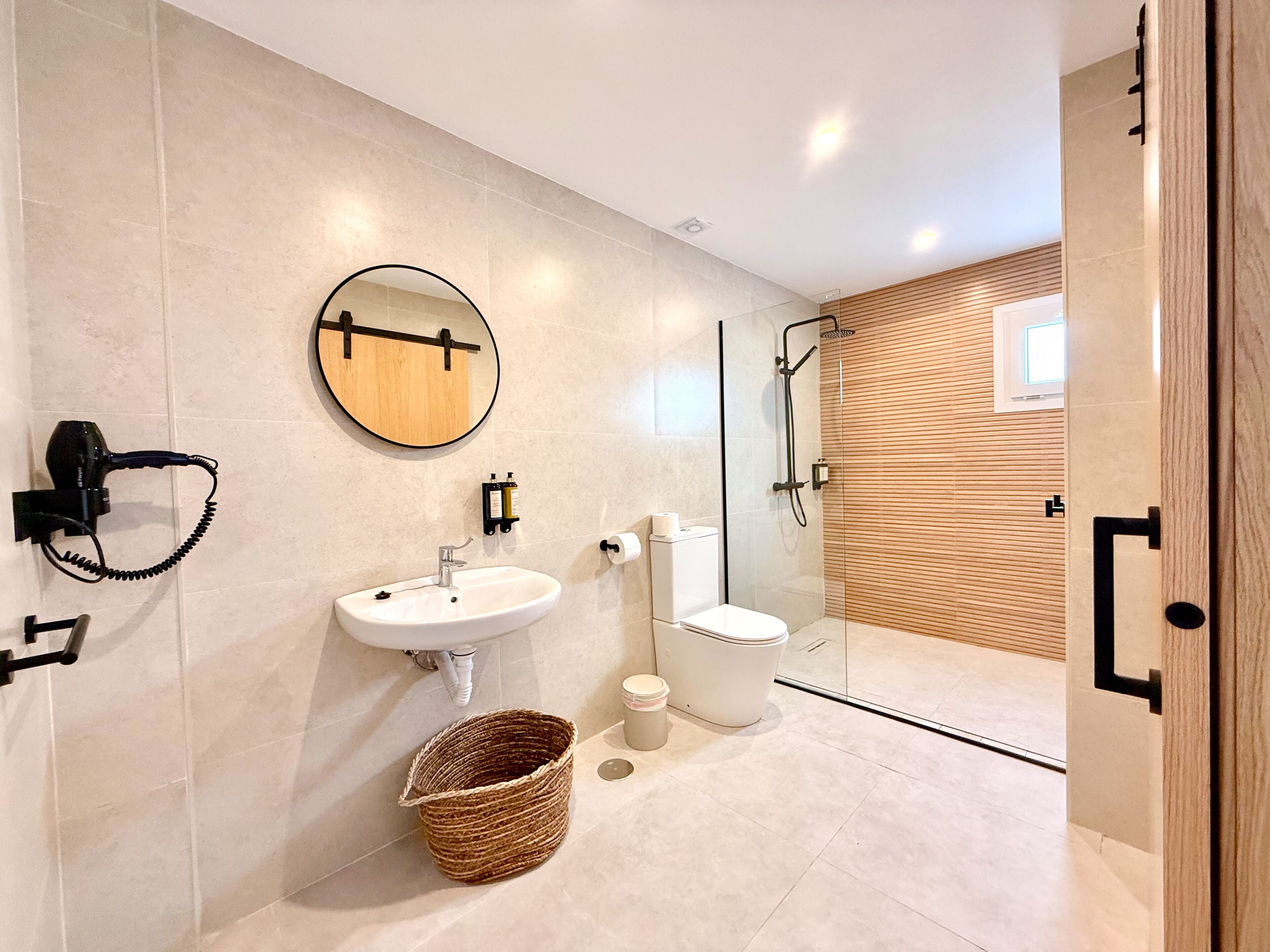 Un baño moderno con lavamanos, inodoro y ducha.