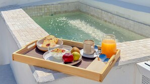 Een ontbijtkarretje met toast, fruit, ontbijtgranen, koffie en sinaasappelsap bij een zwembad.
