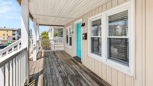 A wooden deck with a white railing, a turquoise door, and a white ceiling with a grid pattern. - Dorchester Drift B: Shore Nest (Ocean City)